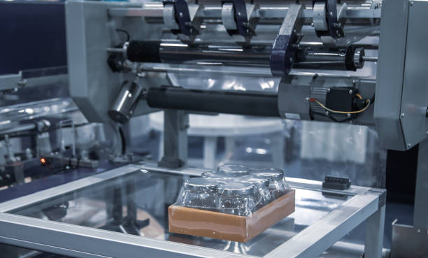 Shrink film wrapping machine. Wraping packaging of jars. Food industry